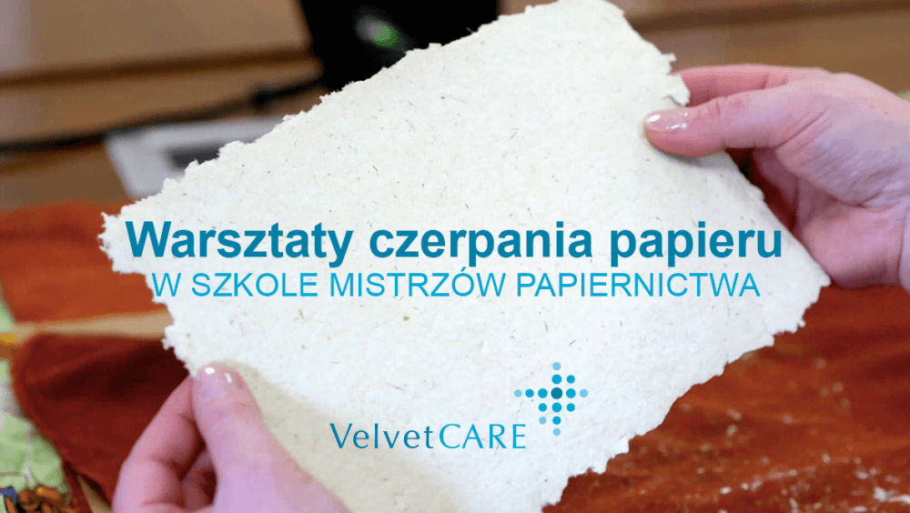 Kobieta trzyma w rękach papier czerpany. Na nim widnieje napis 