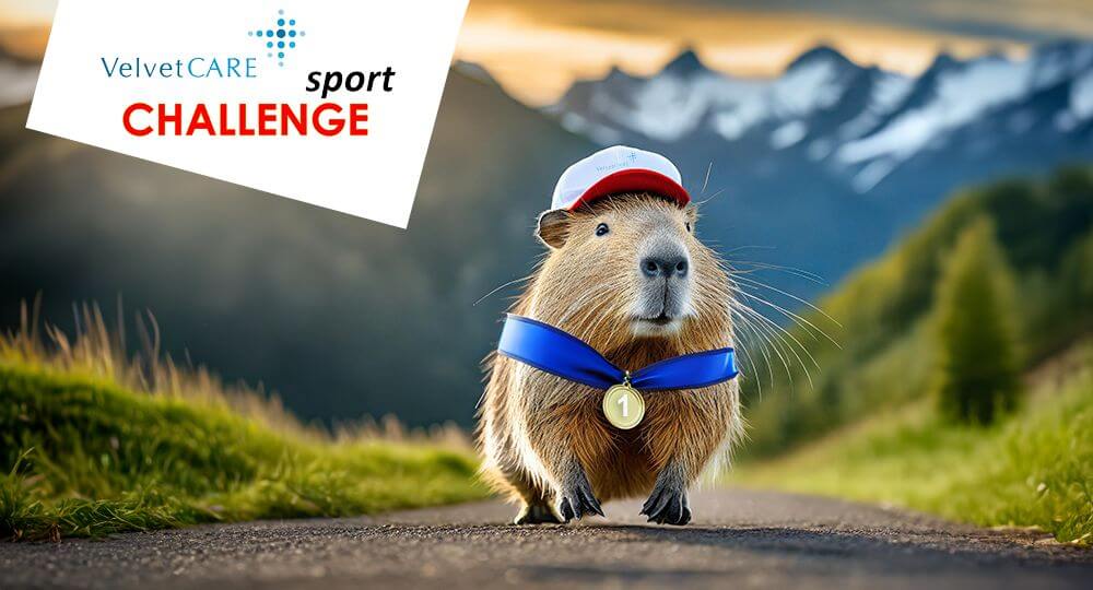 Kapibara z medalem na szyi biegnie drogą. W lewym górnym rogu znajduje się logo projektu Velvet CARE Sport Challenge.